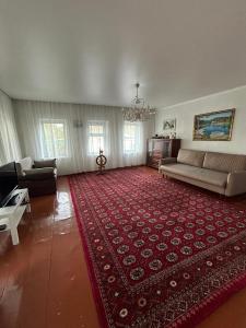 ein großes Wohnzimmer mit einem großen roten Teppich in der Unterkunft Гостевой дом «Орман» in Qarqaraly