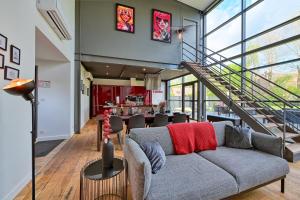ein Wohnzimmer mit einem Sofa und einer Treppe in der Unterkunft Incroyable Villa 5 étoiles 7 minutes du Centre de Lille in Marcq-en-Baroeul