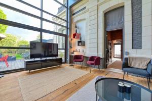 uma sala de estar com uma grande televisão e cadeiras em Incroyable Villa 5 étoiles 7 minutes du Centre de Lille em Marcq-en-Baroeul