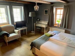a bedroom with a bed and a desk and a chair at Landhotel Ruhepol - garni in Arnstadt