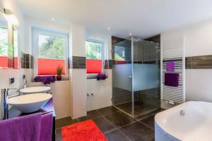 une salle de bain avec deux lavabos, une baignoire et une douche dans l'établissement Moderne Fewo mit Fasssauna und Kamin im ländl. Allgäu, à Eggenthal 23 autres photos