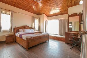 a bedroom with a bed and a wooden ceiling at Ceedar Cottages in Bhīm Tāl