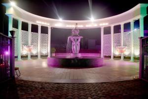uma estátua num edifício com luzes roxas em Nirmal Hotel And Resort em Bareilly