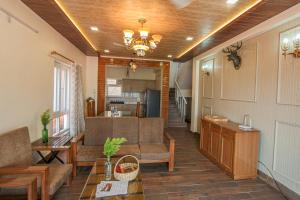 a living room with a couch and a table at Ceedar Cottages in Bhīm Tāl