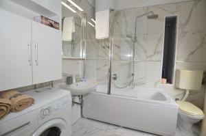 y baño blanco con lavabo y lavadora. en Moris Apartman en Rovinj