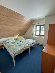 a bedroom with a bed with a wooden ceiling at Čtyřicítka na Šťastném kopci in Cerny Dul