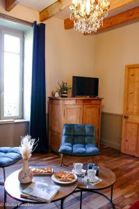 a living room with a table and chairs and a television at Gîte ty nina rosa in Penmarcʼh