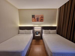 two beds in a small room with at Altori Park Hotel in General Santos