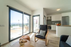 a living room with a view of a kitchen and a chair at Apartment Nascer do Sol in Aljezur