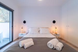 a bedroom with a large bed with towels on it at Apartment Nascer do Sol in Aljezur