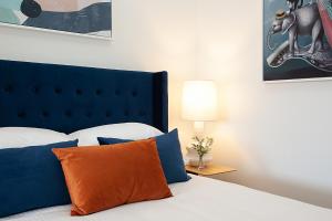 a bedroom with a bed with blue and orange pillows at Spacious Studio With Balcony in Inner-City Glebe in Sydney