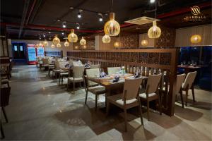 a dining room with tables and chairs and chandeliers at Mandala Apartment Hotel in Bắc Ninh