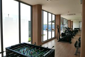 un gimnasio con mesa de billar y equipo de ejercicios en River View Pathum Hotel and Residence en Pathum Thani