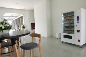 een keuken met een tafel en een koelkast gevuld met drankjes bij River View Pathum Hotel and Residence in Pathum Thani