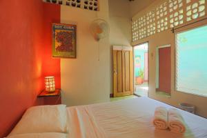 a bedroom with a bed with two towels on it at Hostel De Boca en Boca in Granada