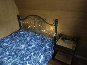 Una cama con un edredón azul con luces. en Battle Pods and Bells en Battle