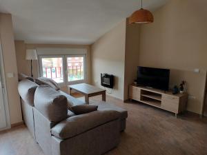 ein Wohnzimmer mit Couch und Fernseher in der Unterkunft Apartamento rural en Sierra de Gredos in San Bartolomé de Pinares