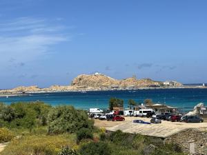 un gruppo di auto parcheggiate in un parcheggio vicino all'acqua di La Piscine - Appt pour 6 climatisé avec piscine a LʼÎle-Rousse