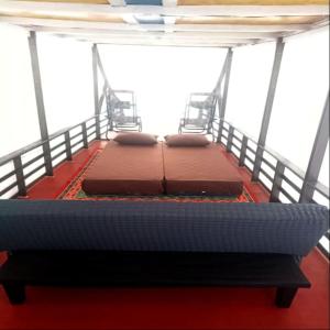 2 Betten auf einem Balkon in der Unterkunft Cakrawala in Kumai