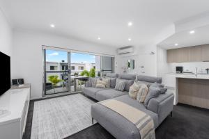 a living room with a couch and a kitchen at Splendido Resort Apartments in Gold Coast