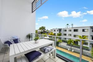 a balcony with a white bench and a view of a building at Splendido Resort Apartments in Gold Coast