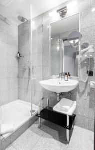 a bathroom with a sink and a shower at TITANIC Comfort Kurfürstendamm in Berlin