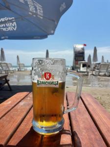 a glass of beer sitting on a table at the beach at Peter Apartmanbulgaria-Imperial Fort Noks in Elenite