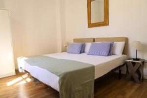 Valencia Luxury - Malvarrosa Beach في فالنسيا: غرفة نوم بسرير كبير مع وسائد زرقاء