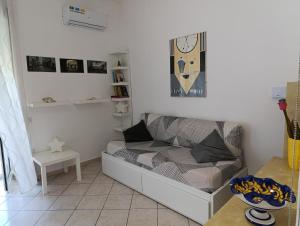 a living room with a couch and a clock on the wall at Casa con ampio giardino e patio in Acerra +9 photos