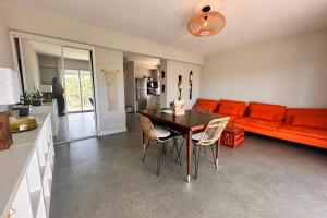 una sala de estar con una mesa y un sofá en Le Neptune Appartement T2 tout confort au calme et à deux pas de la plage, en Le Grau-du-Roi