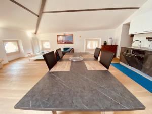 a kitchen and dining room with a long table and chairs at Da Mario Superior Apartment in Malcesine
