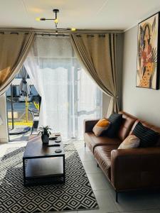 a living room with a couch and a coffee table at Lakhe Lethu Apartment: Green Valley Estate in Nelspruit +44 photos