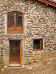 een stenen gebouw met twee ramen en een deur bij Le Four' Nid in La Terrasse-sur-Dorlay