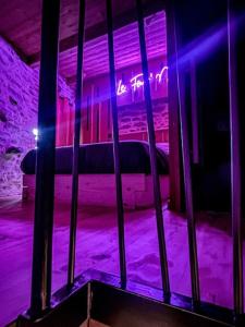 een kamer met een bed in een kamer met paarse verlichting bij Le Four' Nid in La Terrasse-sur-Dorlay