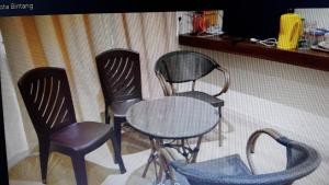 three chairs and a table in a room at Homestay KNK in Tawau