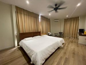 - une chambre avec un grand lit et un ventilateur de plafond dans l'établissement Homestay KNK, à Tawau