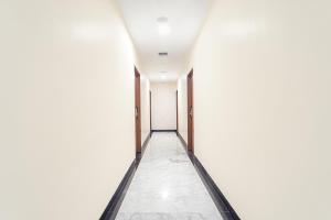 an empty corridor in an office building with white walls at FabHotel Stayz Inn US Consulate in Chennai
