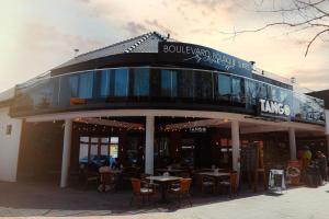a building with tables and chairs in front of it at Boulevard Boutique Suites in Łeba