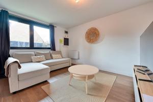 uma sala de estar com um sofá e uma mesa em Le Relais à 7 minutes du Centre de Lille em Marcq-en-Baroeul