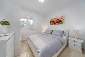 ein weißes Schlafzimmer mit einem Bett und einem Schreibtisch in der Unterkunft Villa Shaula 2 in Bilice