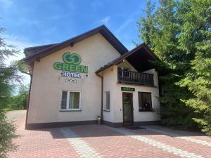 a green roofed building with a green sign on it at Hotel GoGreen *** in Kraków