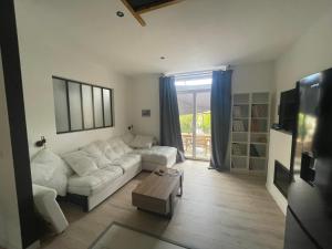 a living room with a white couch and a coffee table at Maison de vacances dans le Diois au pied du Vercors avec 2 chambres pour 6 personnes climatisée in Menglon