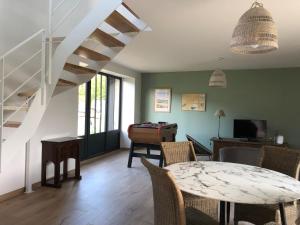 a living room with a staircase and a table at Entre terre et mer in Ploemeur