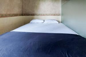 1 dormitorio con 1 cama grande en una habitación en Ni Hotel Syariah Bandara Soekarno Hatta Mitra RedDoorz en Selapajang