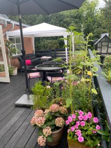 a patio with a table and flowers on a deck at Bøllingsø Bed and Breakfast in Engesvang