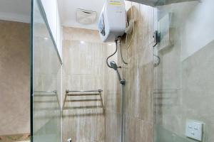 y baño con ducha acristalada. en Ni Hotel Syariah Bandara Soekarno Hatta Mitra RedDoorz en Selapajang