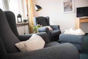a living room with two chairs and a tv at Appartementhaus Westend in Norderney