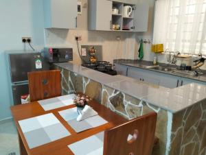 una cucina con bancone, tavolo e sedie di JNJ luxury homes a Naivasha