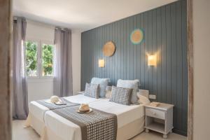 una camera da letto con un grande letto bianco e pareti blu di Apartamentos Royal Life a Mahón