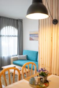 Apartamentos Royal Life في ماهون: غرفة معيشة مع أريكة زرقاء وطاولة